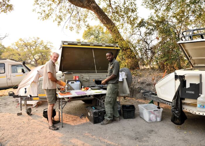 Der Reiseleiter bereitet ein Mittagspicknick auf der Safari durch Zambia vor