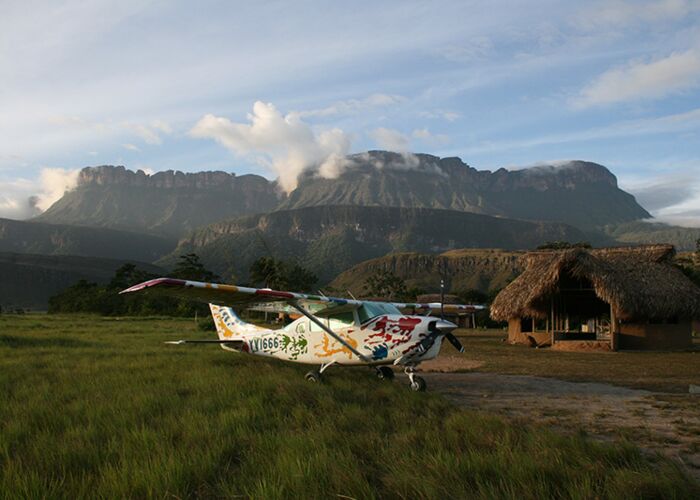 Der Auyan Tepui im Hintergrund von einer strohbedeckten Hütte